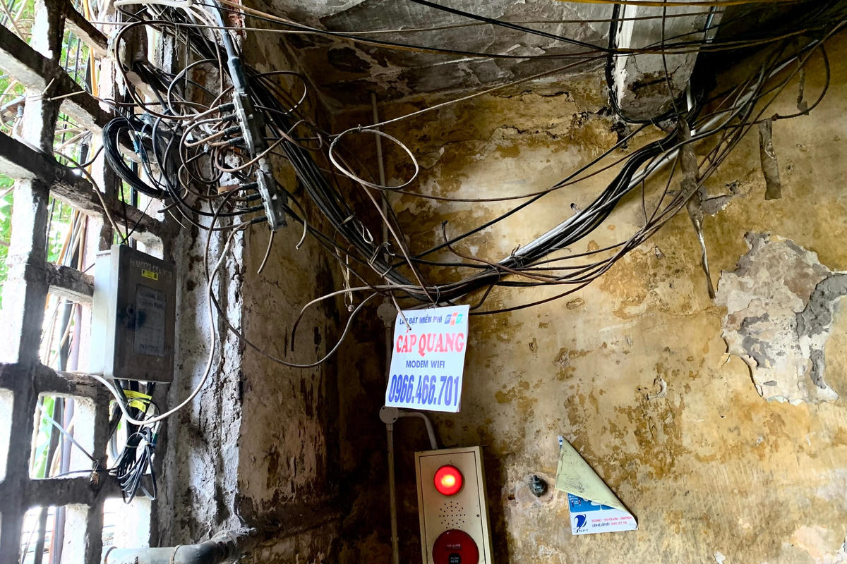 Bên trong khu tập thể, đường dây điện không mấy khả quan. Các đường dây điện treo thấp, người dân phải né mỗi lần đi qua.