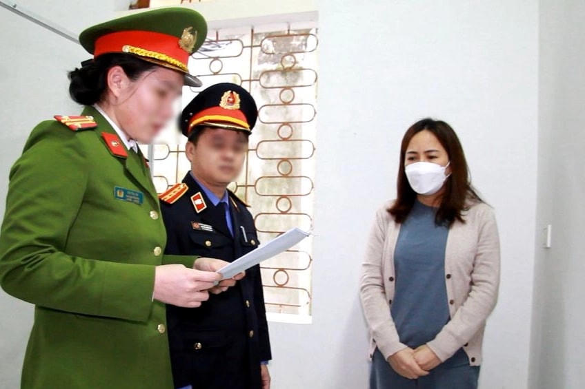 Đại diện Công an tỉnh Nghệ An đọc quyết định khởi tố bị can, lệnh tạm giam đối với Đinh Thị Hòa về tội "Đưa hối lộ" (Ảnh: CANA).