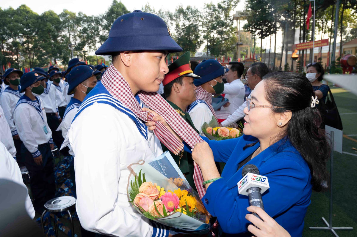 Bà Nguyễn Thị Lệ, Chủ tịch HĐND TPHCM quàng khăn, tặng hoa động viên thanh niên thành phố lên đường nhập ngũ. (Ảnh: X.Khu).