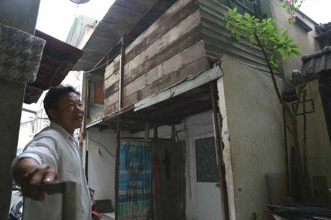 Ông Nguyễn Xuân Phong bên dãy nhà xuống cấp, gần chục năm không thể xây dựng, sửa chữa do chồng lấn ranh dự án. Ảnh: Đình Văn.