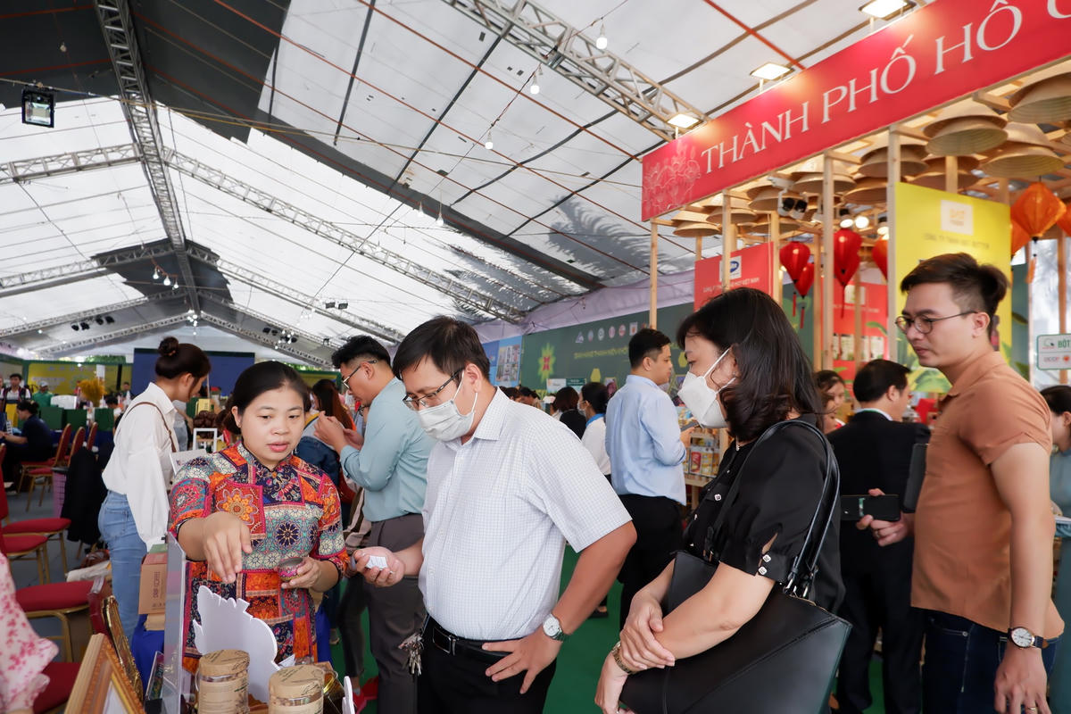 Khách tham quan, mua sắm tại những gian hàng trong Phiên chợ.