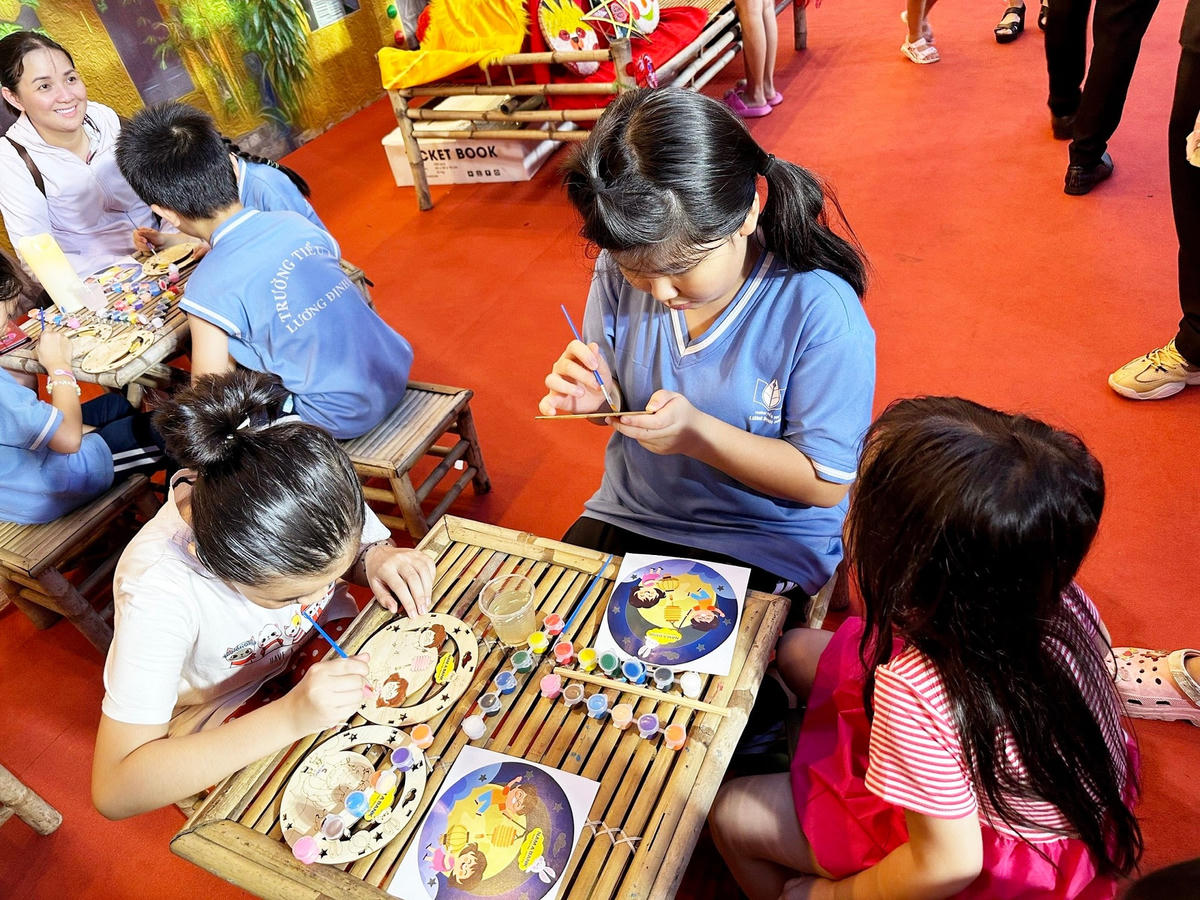 Các em nhỏ là con em của khách hàng và CBNV chăm chú “Tô trăng vàng, vẽ hạnh phúc” tại Phố lồng đèn Nam A Bank.