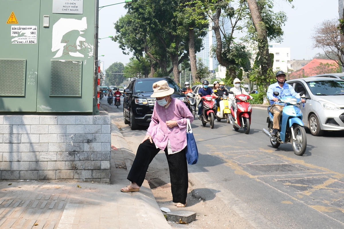 Một cụ già buộc phải đi xuống lòng đường vì bị tủ điện chắn ngang.