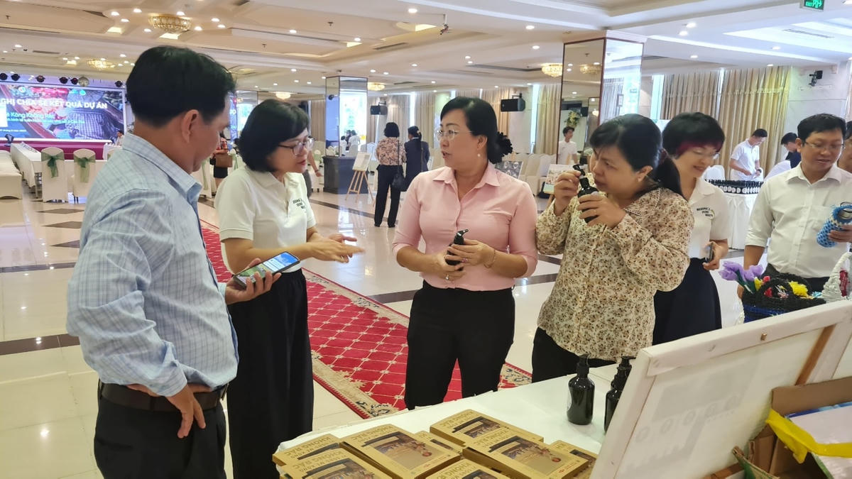 Bà Trần Thị Hoa (thứ hai bên trái sang), giám đốc GreenHub chia sẻ thông tin về sản phẩm nước tẩy rửa từ vỏ trái cây với đại biểu tham dự.