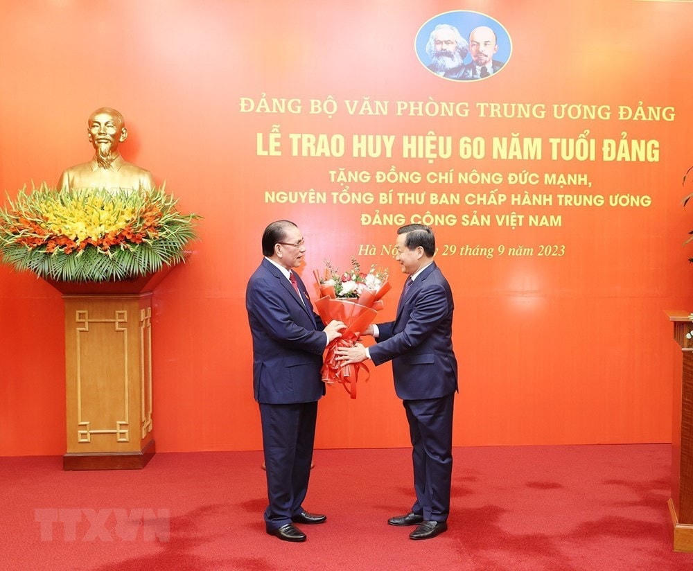 Đồng chí Lê Minh Khái, Bí thư Trung ương Đảng, Phó Thủ tướng Chính phủ, thay mặt Ban Cán sự Đảng Chính phủ chúc mừng nguyên Tổng Bí thư Nông Đức Mạnh. (Ảnh: Trí Dũng/TTXVN).