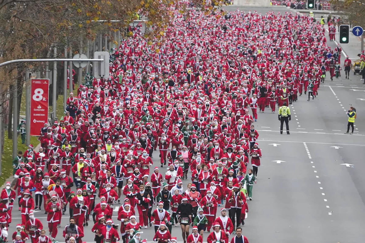 Người tham gia làm ông già Noel tụ họp trên những con phố tại thủ đô Madrid (Tây Ban Nha). Ảnh: Paul White/AP. 