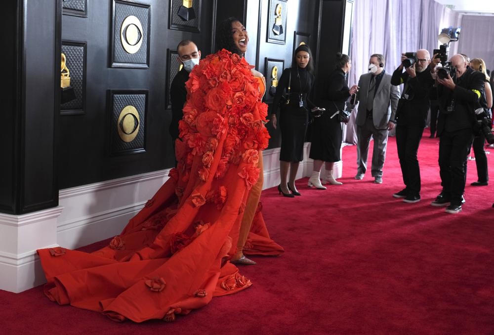 Lizzo bước trên thảm đỏ Grammy với chiếc áo khoác nặng kéo theo chiếc đuôi dài. Ảnh: AP.