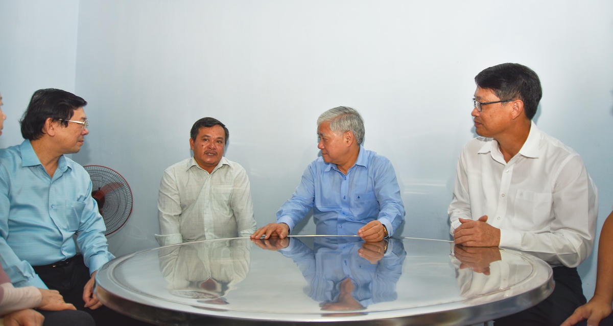 Chủ tịch Đỗ Văn Chiến và Đoàn công tác ân cần thăm hỏi, động viên ông Hứa Chấn Rân vượt qua khó khăn của bệnh tật, ổn định cuộc sống từ ngôi nhà Đại đoàn kết. Ảnh: Thanh Tùng.