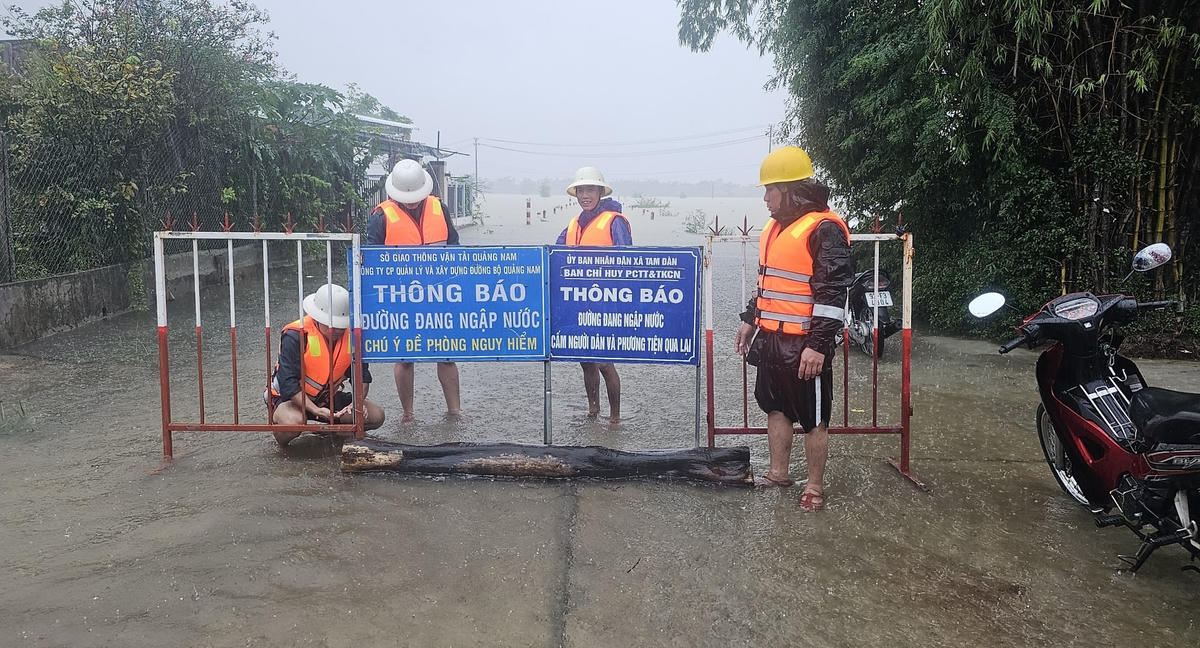 Lực lượng chức năng cấm phương tiện lưu thông đoạn đường ngập nước.