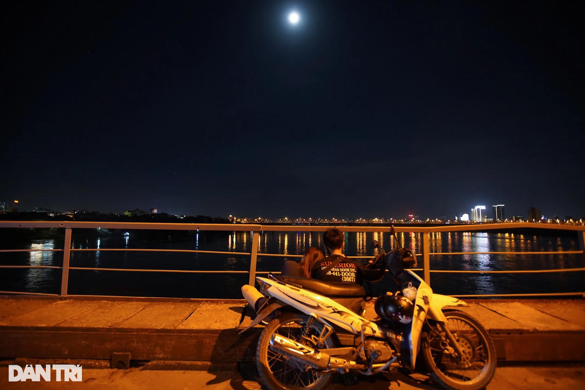 Một đôi bạn trẻ dừng xe trên cầu Long Biên, ngồi bên nhau cùng ngắm trăng tròn (Ảnh: Trịnh Nguyễn).