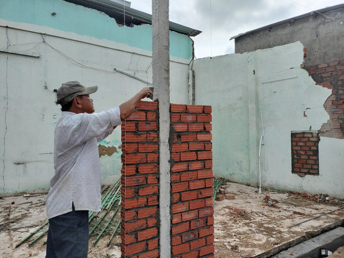 Người dân xây dựng lại nhà bị hư hỏng sau bão.