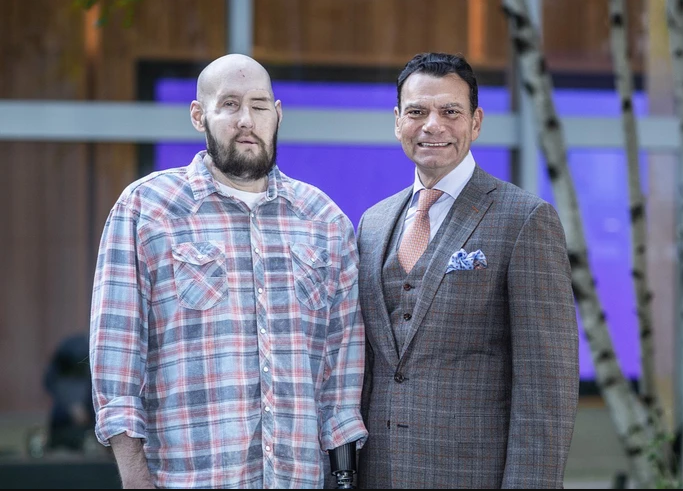 Bệnh nhân Aaron James (trái) với một phần khuôn mặt bao gồm mắt trái, mũi, miệng, hai bên gò má được cấy ghép vào năm ngoái. Bên phải là TS Eduardo Rodriguez. Nguồn: NYU LANGONE HEALTH.