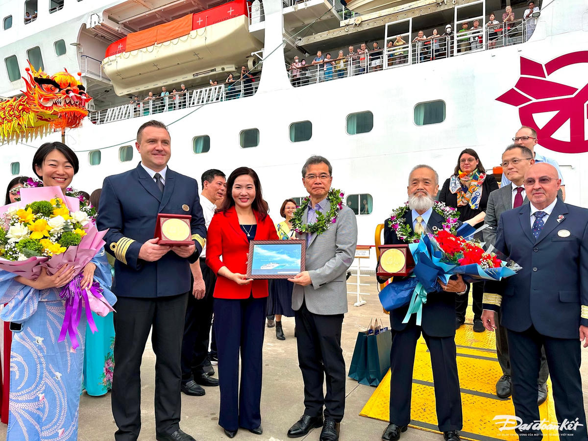 Phó Chủ tịch UBND tỉnh Quảng Ninh Nguyễn Thị Hạnh tặng hoa và quà lưu niệm cho đoàn du khách trên tàu Pacific World. Ảnh: Ngọc Anh.