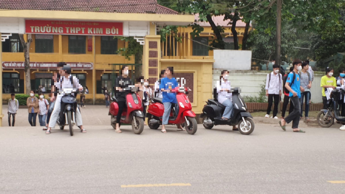 Nhiều học sinh Trường THPT Kim Bôi điều khiển xe máy, xe đạp điện đến trường mà không đội mũ bảo hiểm.