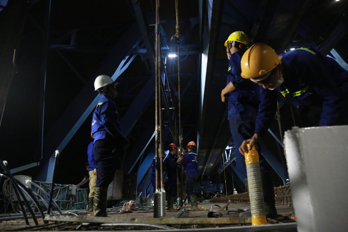 Các công nhân kiểm tra hệ thống khung thép tỉ mỉ trước khi đổ bê tông.