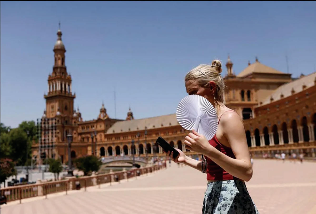 Một cô gái cầm quạt để làm mát tại Madrid, Tây Ban Nha. ẢNH: REUTERS.  