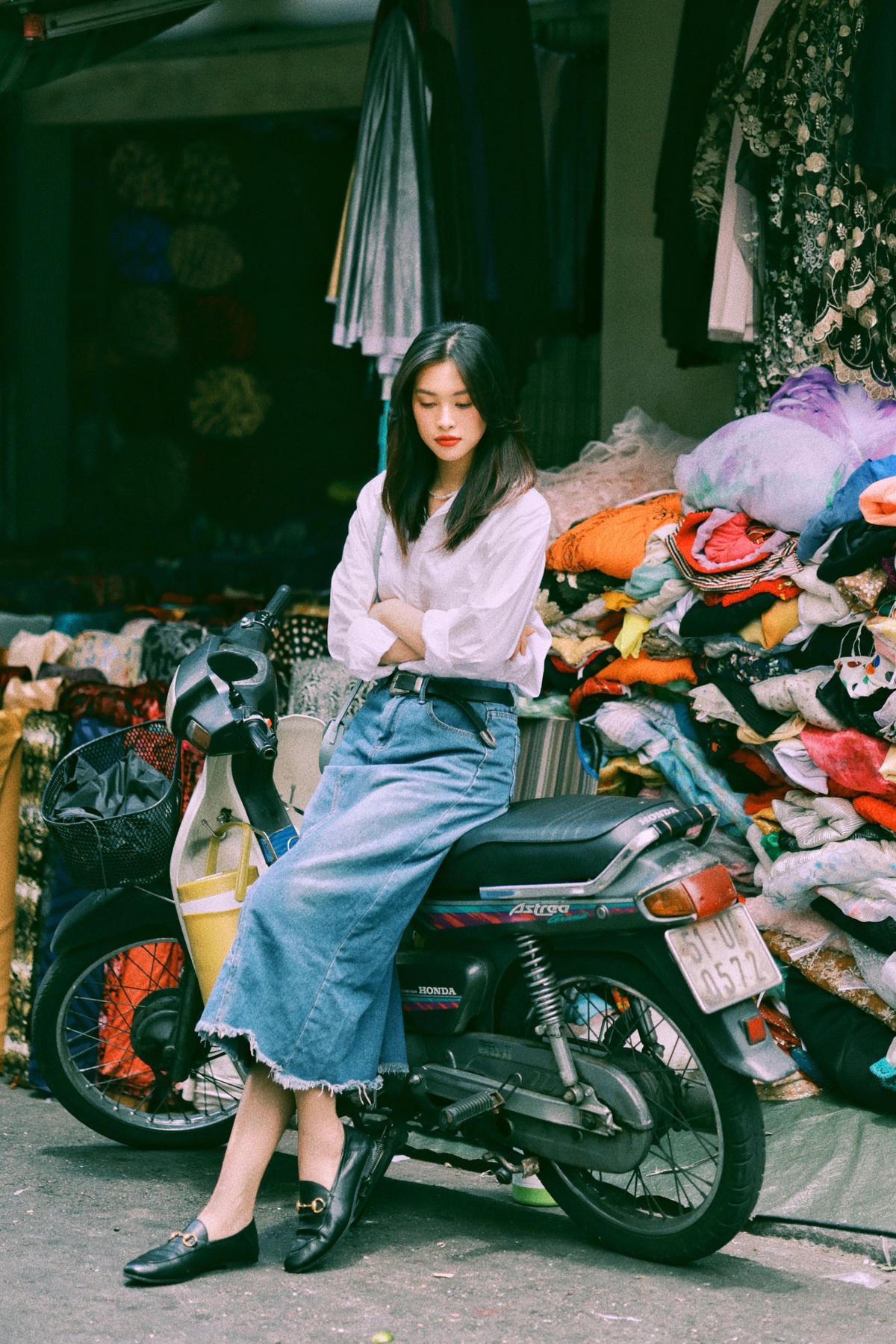 Nàng Hậu chọn phối áo sơ mi cùng chiếc váy jean vintage, điểm xuyết thắt lưng đen và đôi giày loafer cổ điển.