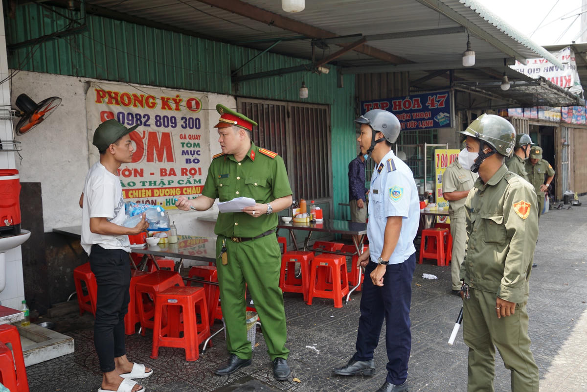 Công an phường Bình Thắng tuyên truyền, vận động, nhắc nhở các quán cơm thực hiện đúng cam kết không chèo kéo khách mua cơm giữa quốc lộ. Nếu bị phát hiện sẽ có chế tài xử phạt nặng. Ảnh: Mạnh Thìn.
