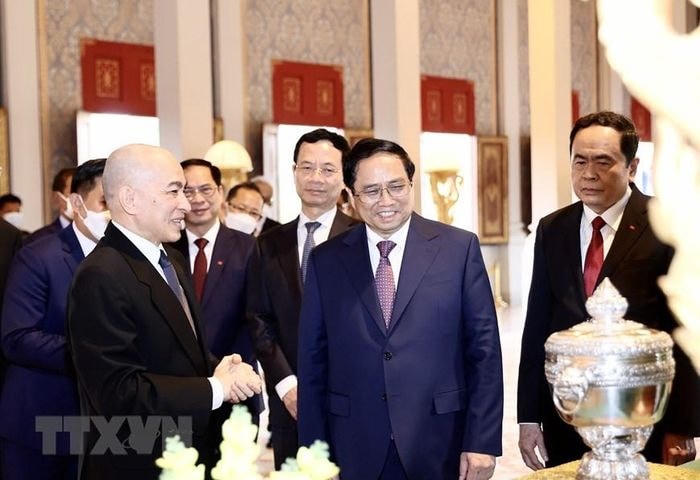 Quốc vương Campuchia Norodom Sihamoni giới thiệu với Thủ tướng Phạm Minh Chính một số tặng phẩm của Hoàng cung. (Ảnh: Dương Giang/TTXVN).