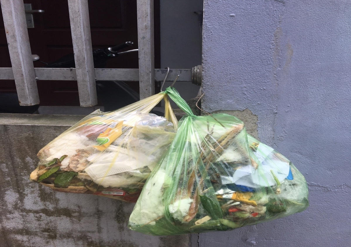 Và dùng móc “tự chế” để treo túi nilon đựng rác lên trước cổng nhà.