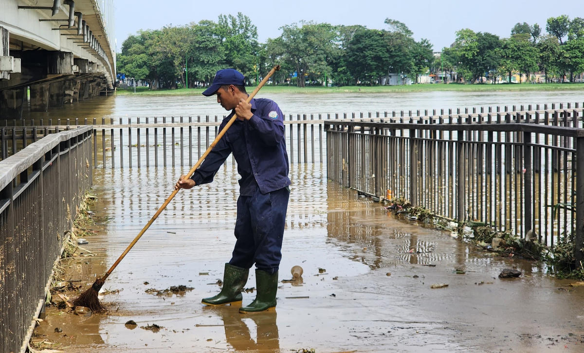 Một lượng bùn đất lớn bám trên cầu gỗ lim sau khi nước lũ dâng gây ngập lụt.