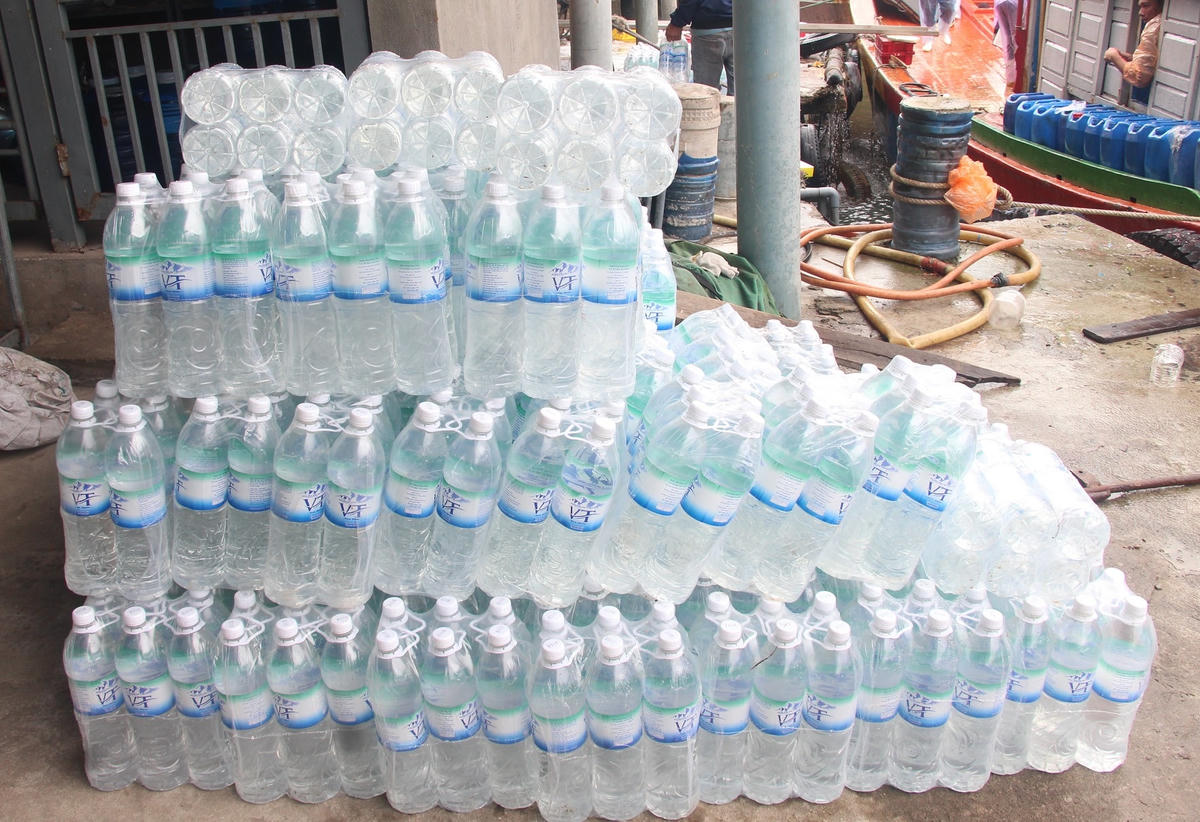 Nhiều chai nước uống được ngư dân đưa lên tàu.