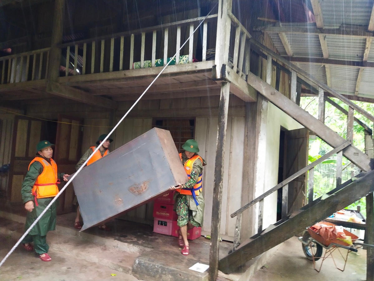 Cán bộ chiến sỹ Đồn Biên phòng Làng Mô (Quảng Bình) giúp người dân di chuyển đồ đạc lên cao, tránh thiệt hại do mưa lũ.