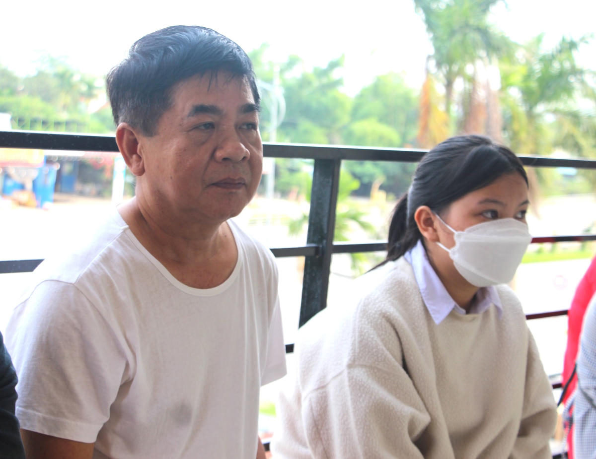Ông  Nguyễn Quốc Tùng (trái) chờ cài đặt tài khoản định danh điện tử VNelD.