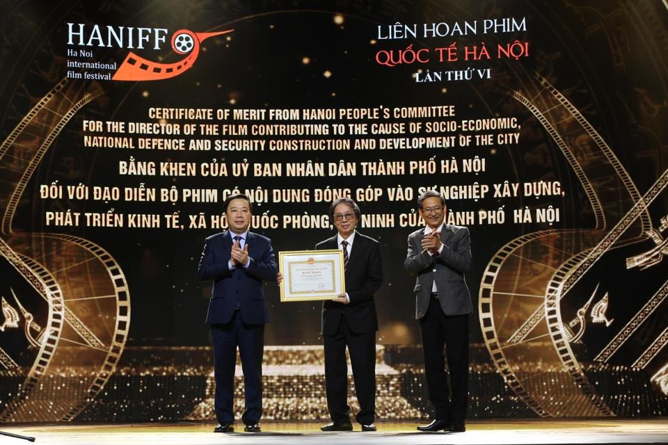 Phó Chủ tịch UBND TP Hà Nội Chử Xuân Dũng (trái) trao Bằng khen cho NSND Đặng Nhật Minh, đạo diễn bộ phim “Hoa nhài”, có nội dung đóng góp vào sự nghiệp xây dựng và phát triển thành phố.