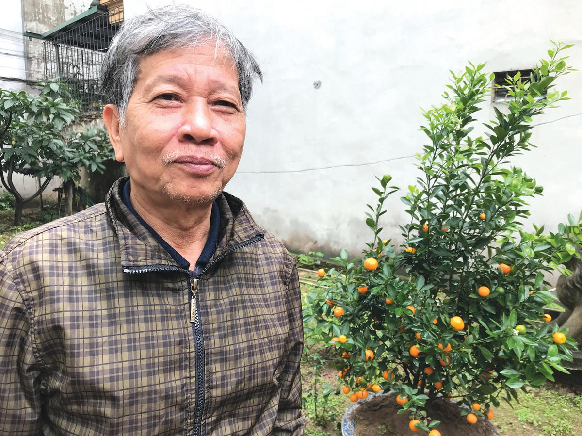 Nhà văn Nguyễn Huy Thiệp bên cây quất trong vườn nhà, mùa xuân năm 2020.  (Ảnh: Hoàng Thu Phố).