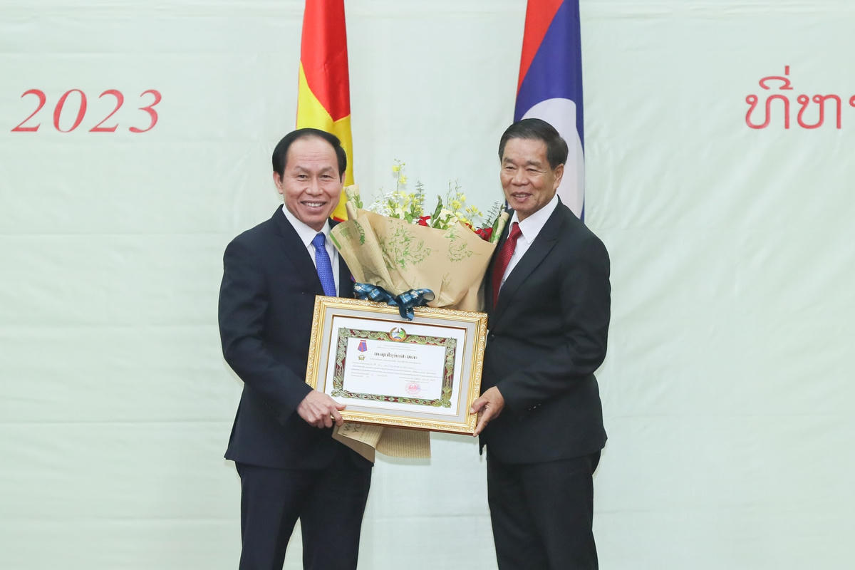 Chủ tịch Ủy ban Trung ương Mặt trận Lào xây dựng đất nước Sinlavong Khoutphaythoune trao Huân chương cho Bí thư Thành ủy Hải Phòng Lê Tiến Châu.