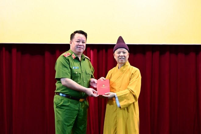 Thiếu tướng Nguyễn Quốc Hùng - Cục trưởng Cục Quản lý hành chính về trật tự xã hội - Bộ Công an trao sổ hướng dẫn tự đăng ký kích hoạt cho Hòa thượng Thích Thanh Quyết.