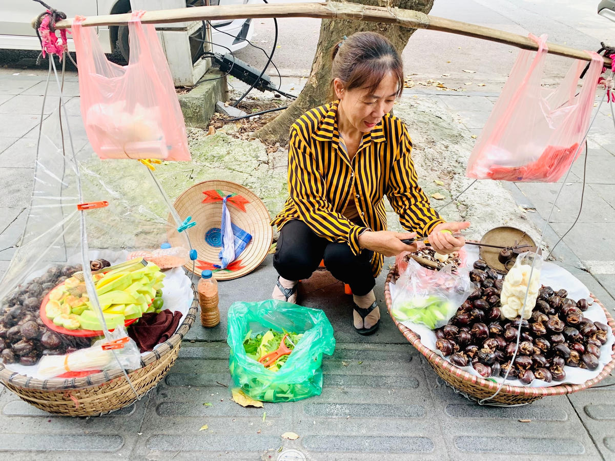 Chị Hải (49 tuổi) bên gánh hàng của mình.