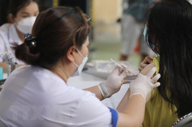 Nhân viên y tế tiêm vaccine cho học sinh. Ảnh: TTXVN.