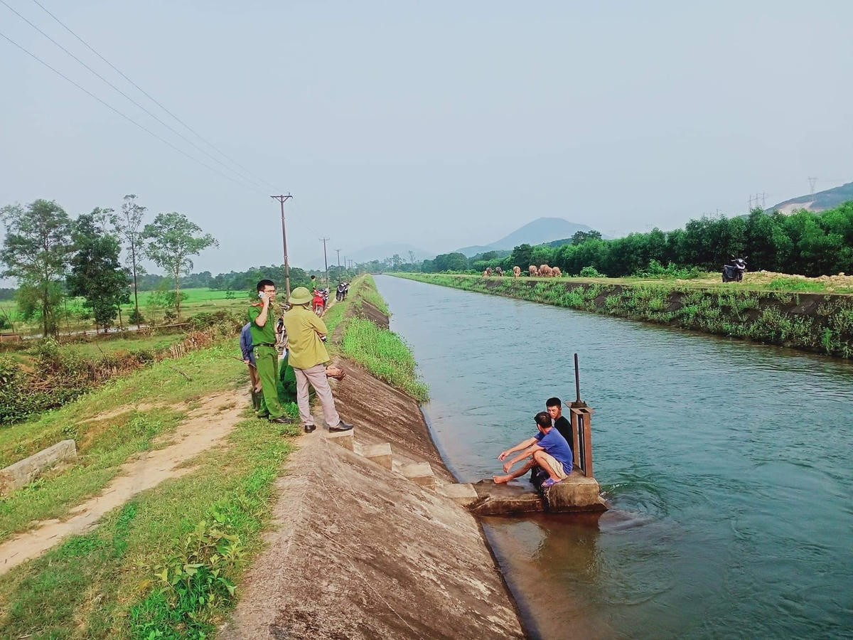Lực lượng chức năng cùng người dân tìm kiếm thi thể học sinh bị nước cuốn trôi trên kênh N01A.