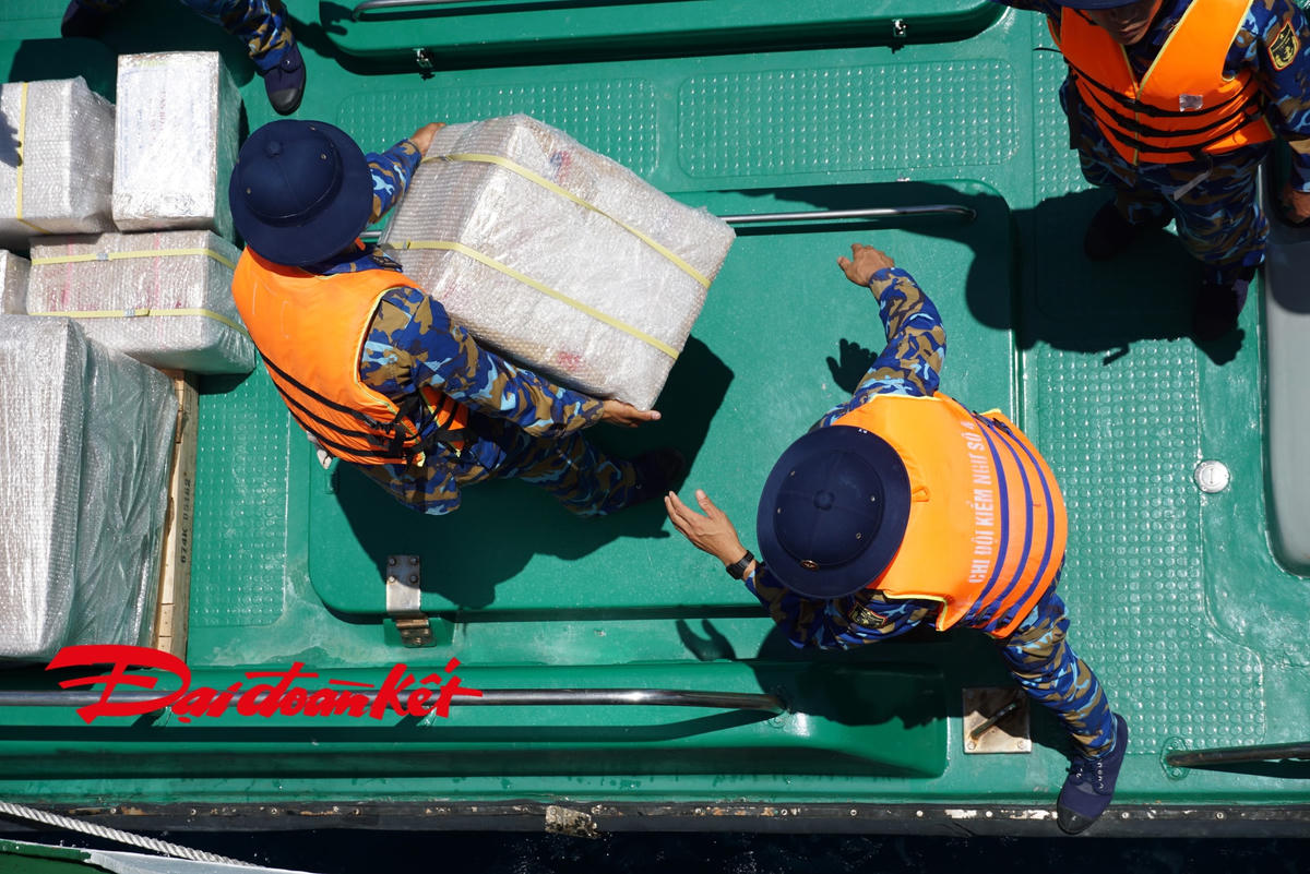 Dưới thời tiết khắc nghiệt của biển khơi, lực lượng bốc hàng phải thao tác nhanh nhất để tránh bị mất sức. Ảnh: Mạnh Thìn.