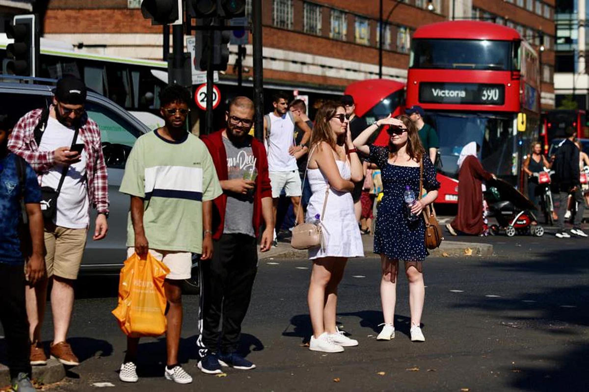Người dân London (Anh) chờ xe buýt dưới thời tiết nắng nóng. Ảnh: Reuters.