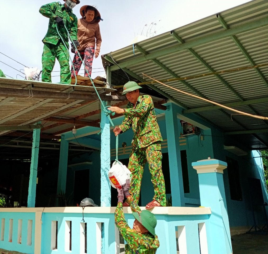 Đưa các bao cát lên mái nhà để chằng chống nhà cửa.