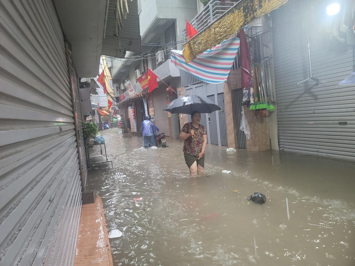 Hà Nội nhiều khu vực ngập trắng đường, người dân vất vả dắt xe, lội nước