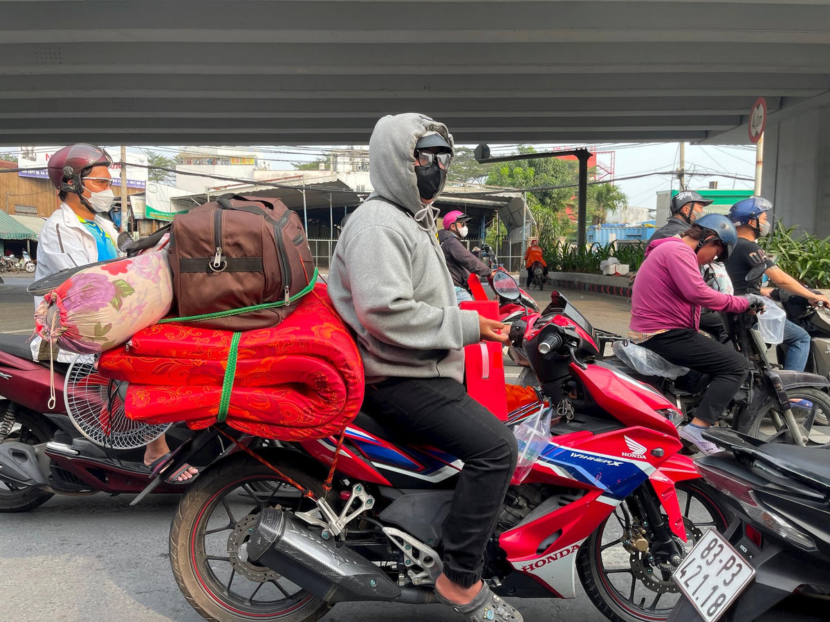Người dân lỉnh kỉnh đồ đạc trên đường về quê ăn tết.