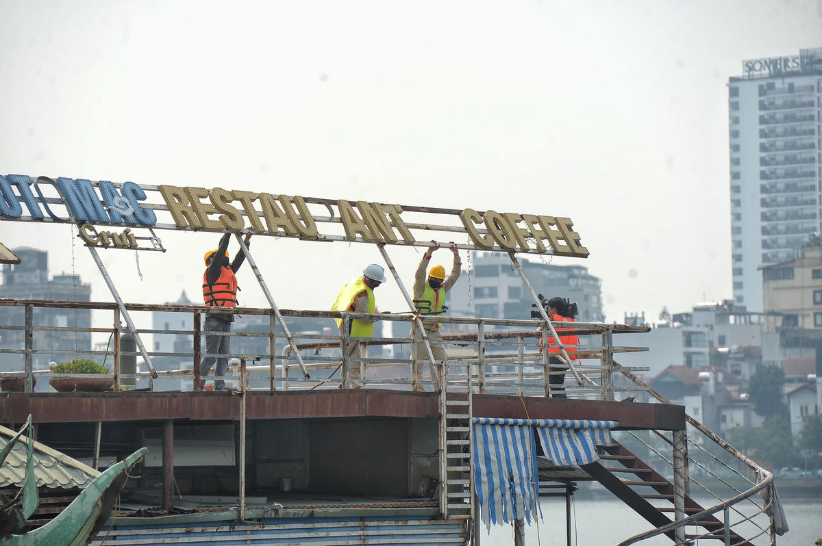 Các bộ phận của chiếc bến cập du thuyền đang được các công nhân tháo dỡ.