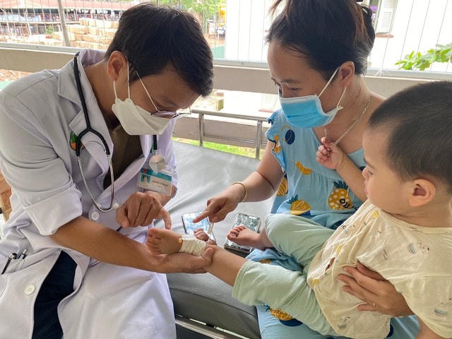 Bác sĩ Nguyễn Đình Qui thăm khám cho một bệnh nhân bị nhiễm tay chân miệng.