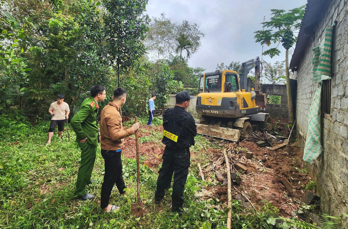 Lực lượng chức năng huy động phương tiện, máy móc để khám xét chỗ ở của vợ chồng bị can Trần Quốc Phùng.