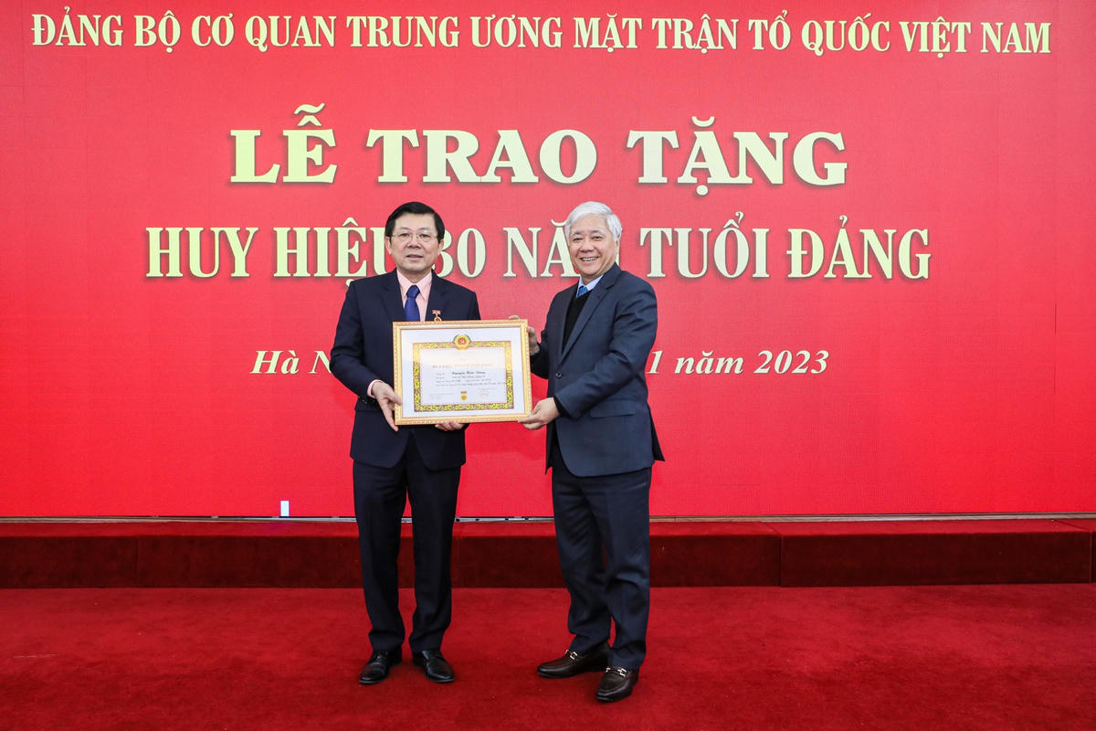 Ông Đỗ Văn Chiến, Chủ tịch UBTƯ MTTQ Việt Nam trao tặng Huy hiệu 30 năm tuổi Đảng cho Phó Chủ tịch Nguyễn Hữu Dũng