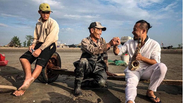 Nghệ sĩ Saxophone Lê Duy Mạnh gặp gỡ ngư dân vùng biển Nam Định khi quay MV "Hello Việt Nam".  