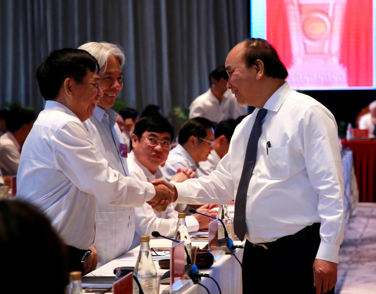 Chủ tịch nước Nguyễn Xuân Phúc trò chuyện với các đại biểu tại hội thảo.