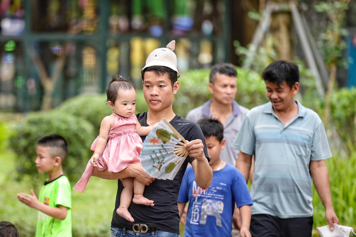 Thời tiết khá oi bức, người lớn, trẻ nhỏ toát mồ hôi khi dạo quanh công viên.