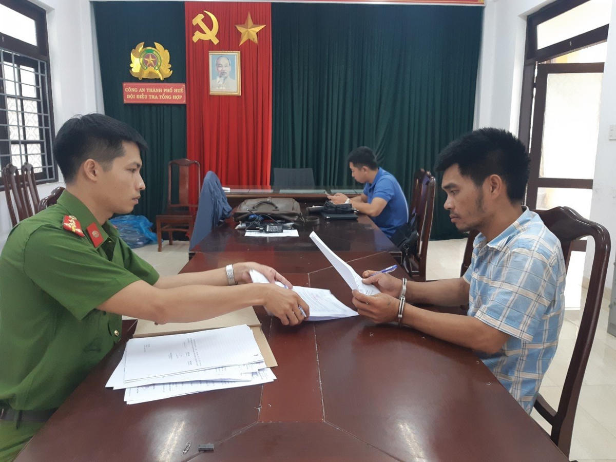 Đối tượng Phan Đình Minh Tuấn (bìa phải) tại cơ quan Công an.