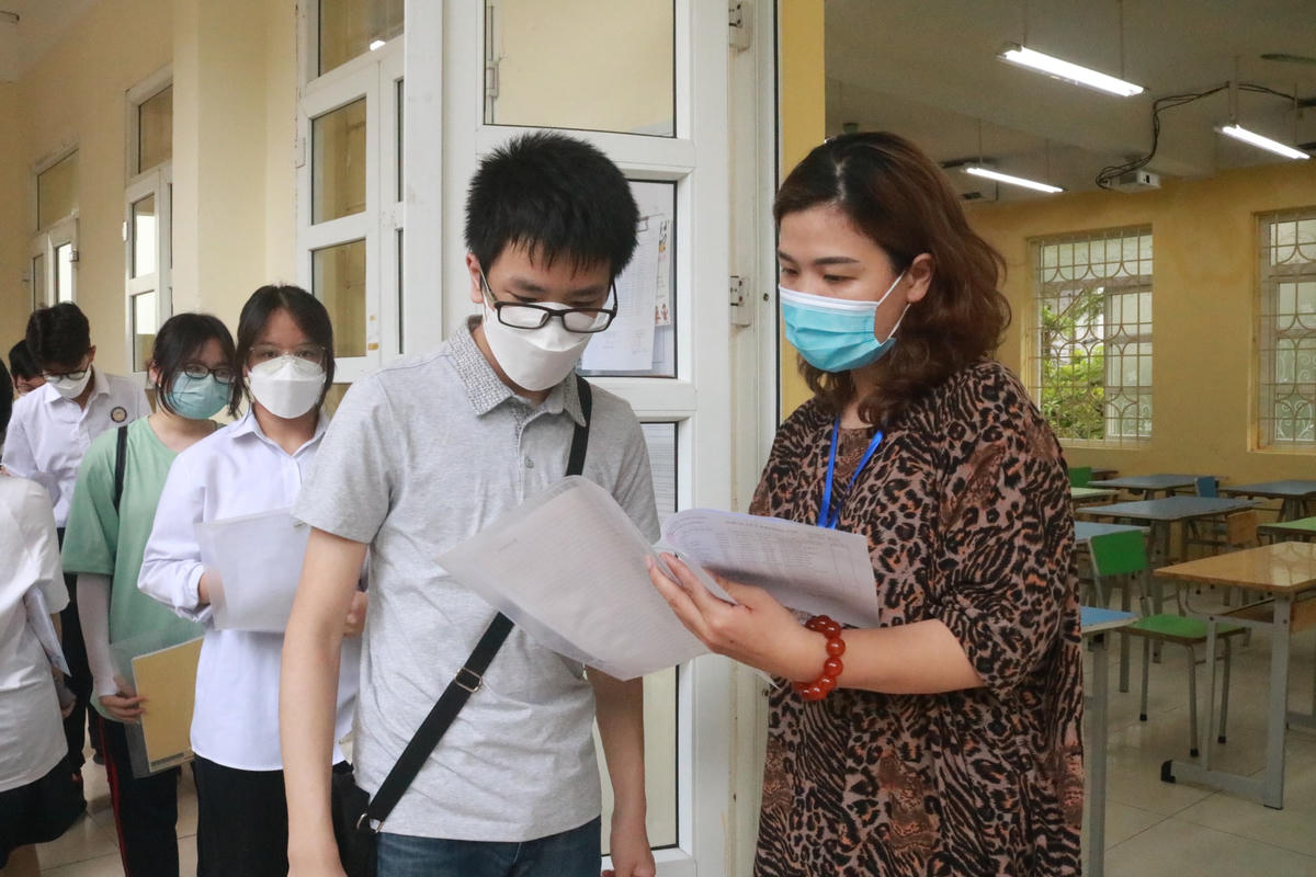 Cán bộ coi thi kiểm tra thông tin thí sinh trước khi dự thi vào lớp 10 THPT công lập năm 2022.