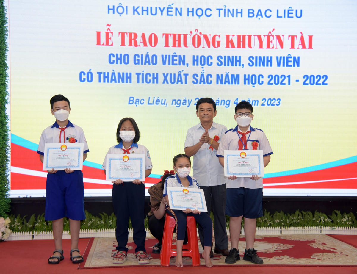 Ông Nguyễn Bá Long, Phó Giám đốc Sở GD&ĐT khen thưởng cho học sinh khuyết tật đạt loại giỏi năm học 2021 - 2022.
